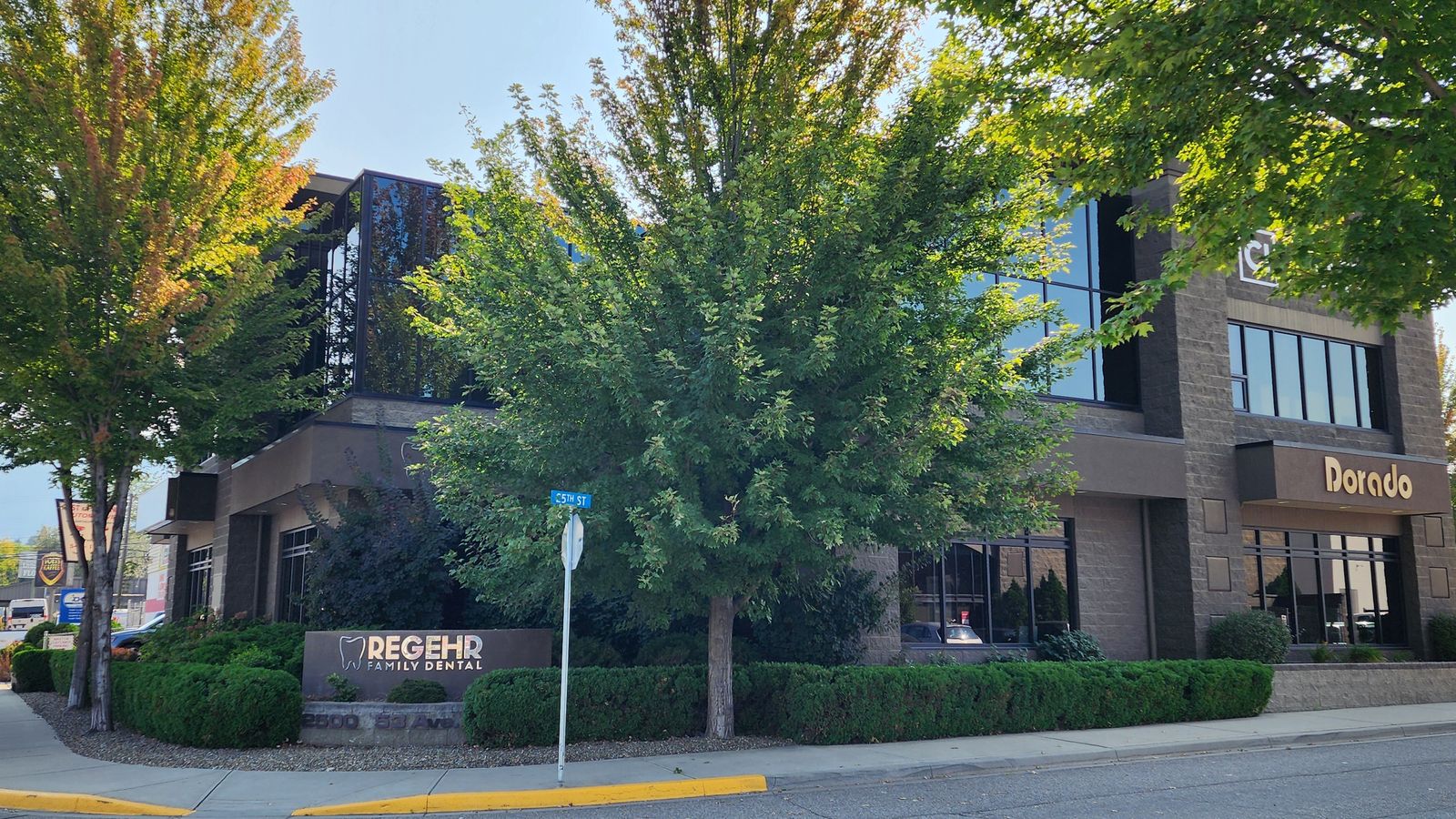 2500 53 Avenue from the street, with mature trees and building signage