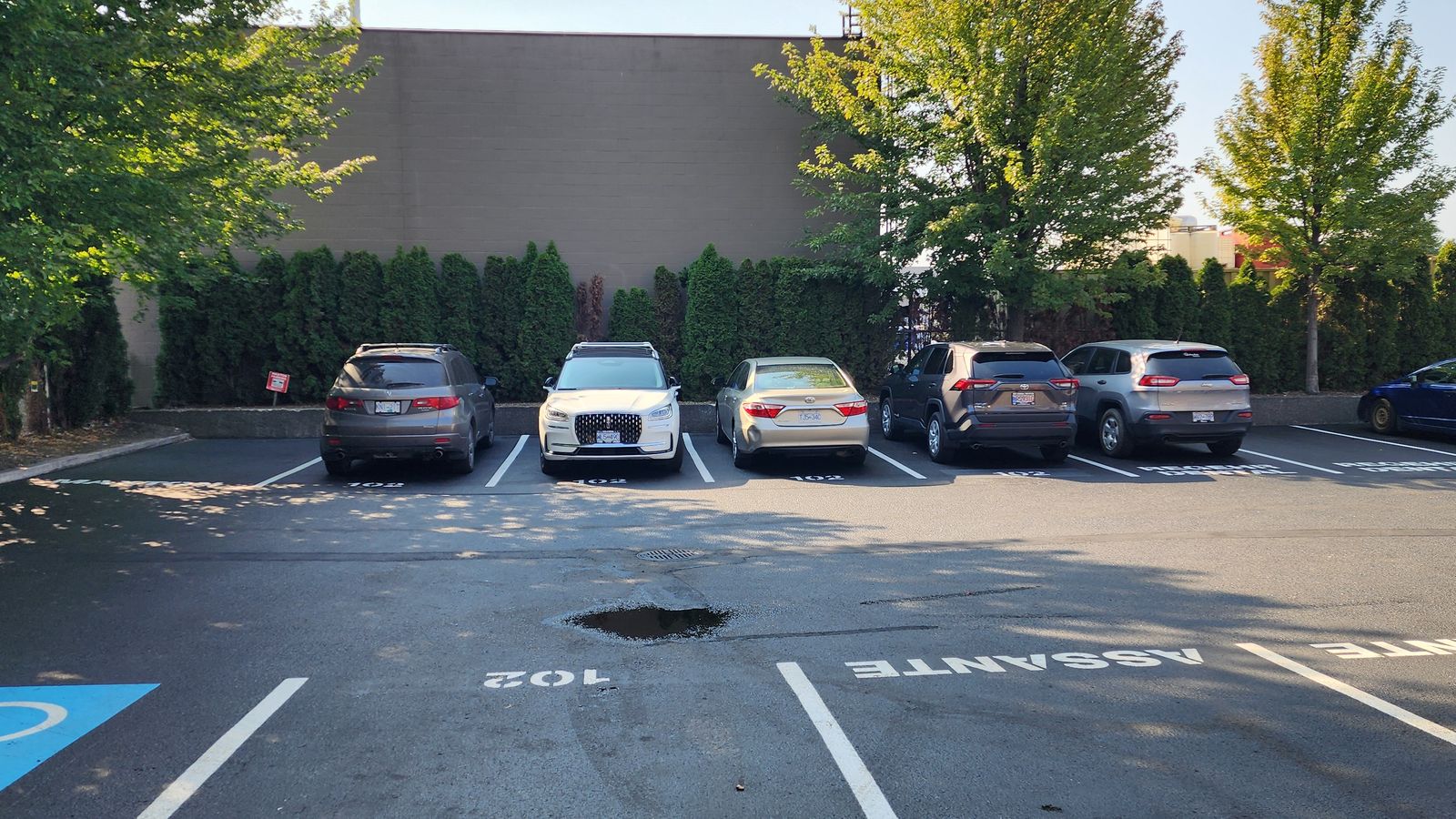 Rear parking lot with designated stalls, including Unit 102